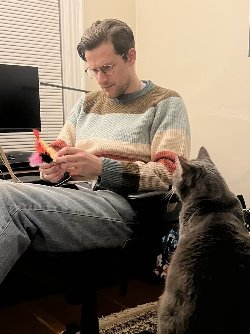 me fixing a cat toy with a captive audience (a cat)